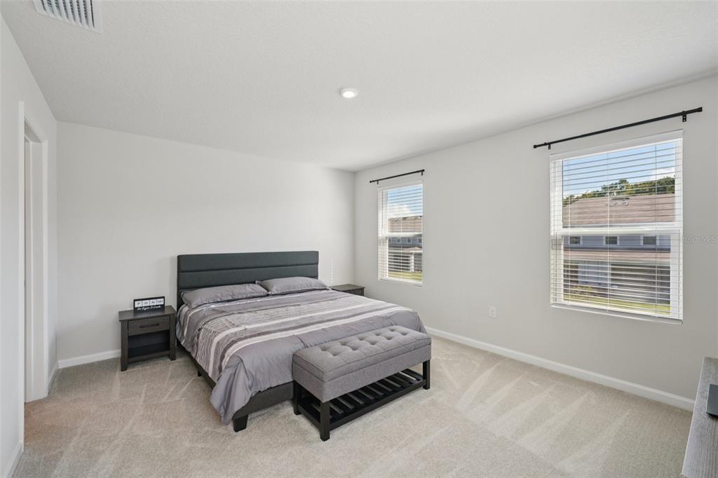 12057 Grizzly Lane New Port Richey, FL 34654 - Photo 12 of 25 a bedroom with a bed lamp and window