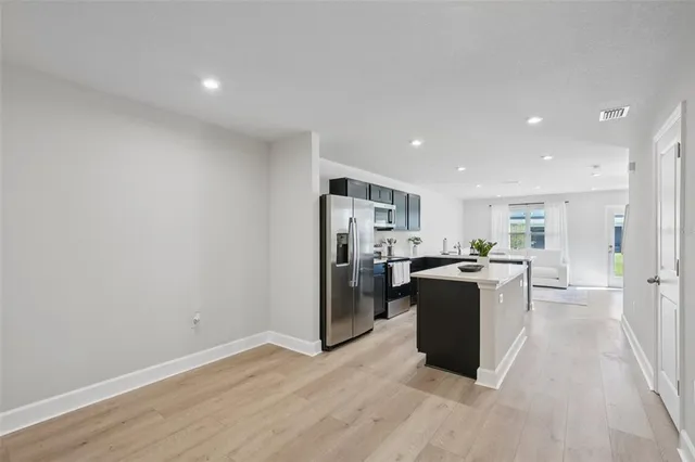 a living room with hard wood floors and a kitchen