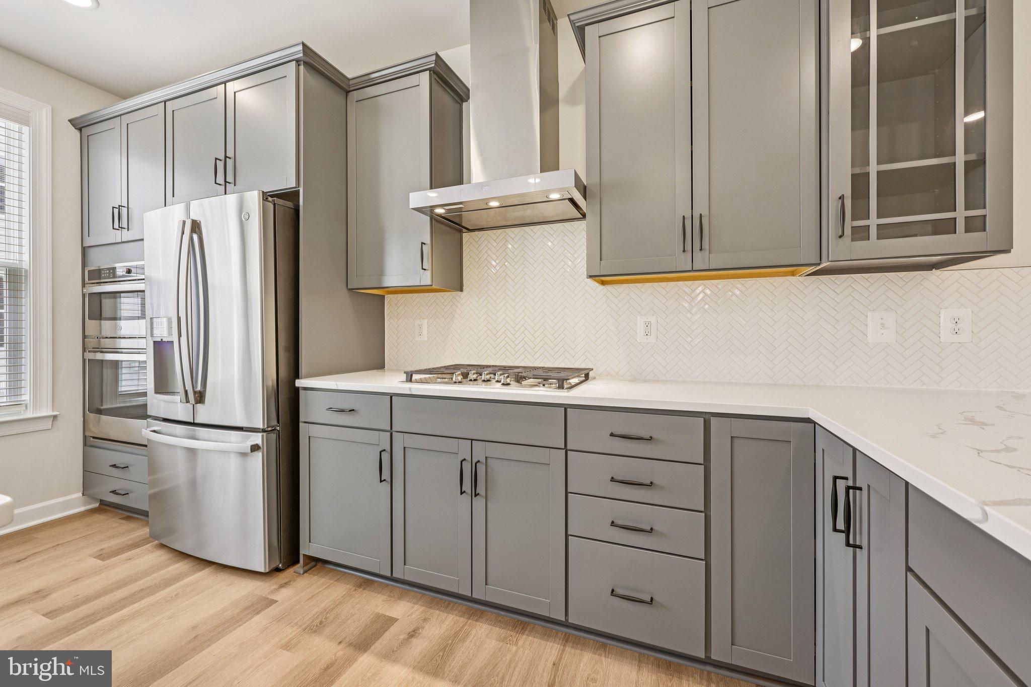 7355 Mountaineer Drive Alexandria, VA 22306 - Photo 4 of 47 a kitchen with cabinets stainless steel appliances and a wooden floor