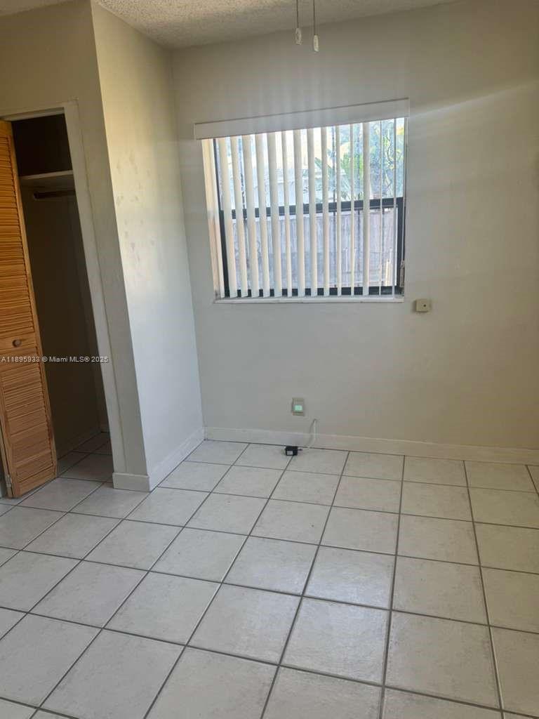 2343 Northwest 28th Street, Unit 12 Oakland Park, FL 33311 - Photo 14 of 34 a view of an empty room with a window