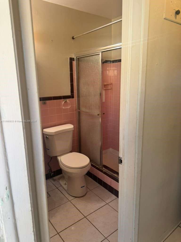 2343 Northwest 28th Street, Unit 12 Oakland Park, FL 33311 - Photo 15 of 34 a bathroom with a toilet and a shower