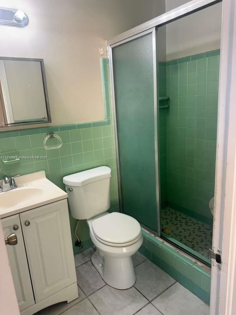 2343 Northwest 28th Street, Unit 12 Oakland Park, FL 33311 - Photo 16 of 34 a bathroom with a toilet a sink and shower