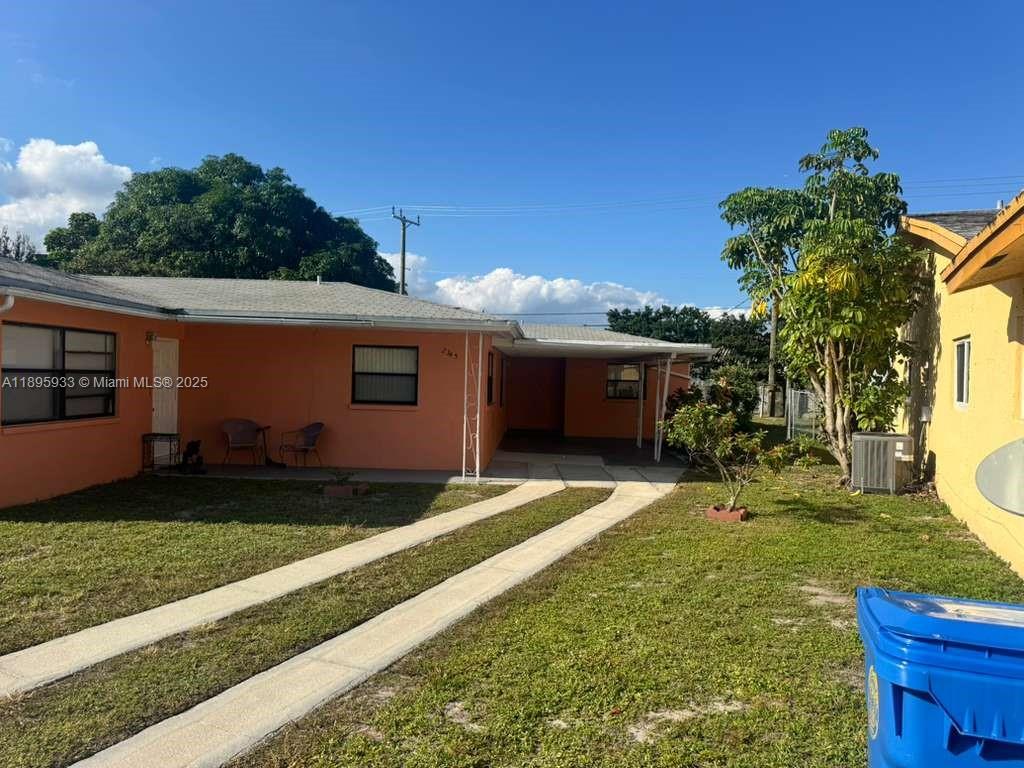 2343 Northwest 28th Street, Unit 12 Oakland Park, FL 33311 - Photo 2 of 34 a front view of a house with garden
