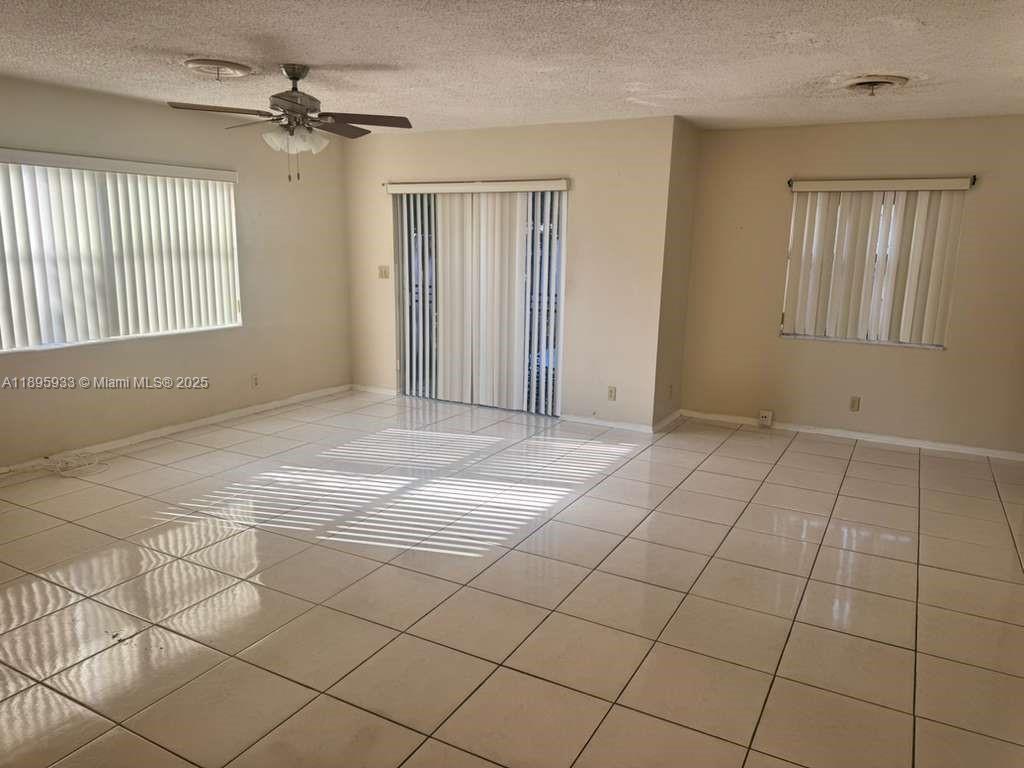 2343 Northwest 28th Street, Unit 12 Oakland Park, FL 33311 - Photo 10 of 34 a view of an empty room with window and chandelier fan