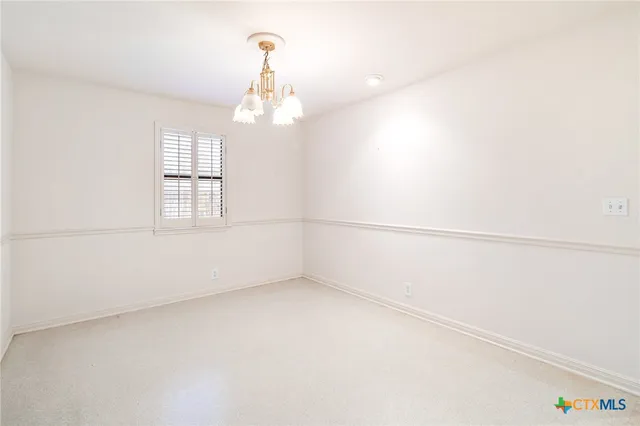 an empty room with chandelier fan