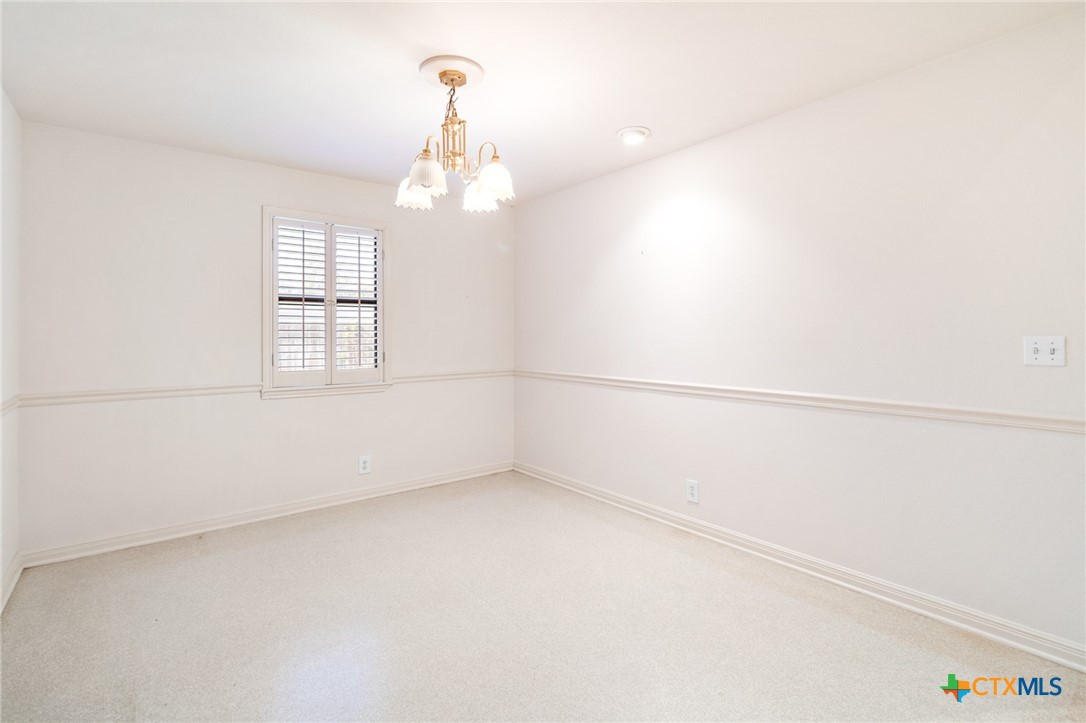 603 Suzanne Street Edna, TX 77957 - Photo 12 of 45 an empty room with chandelier fan