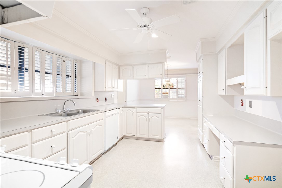 603 Suzanne Street Edna, TX 77957 - Photo 16 of 45 a large white kitchen with cabinets a sink a window and a stove
