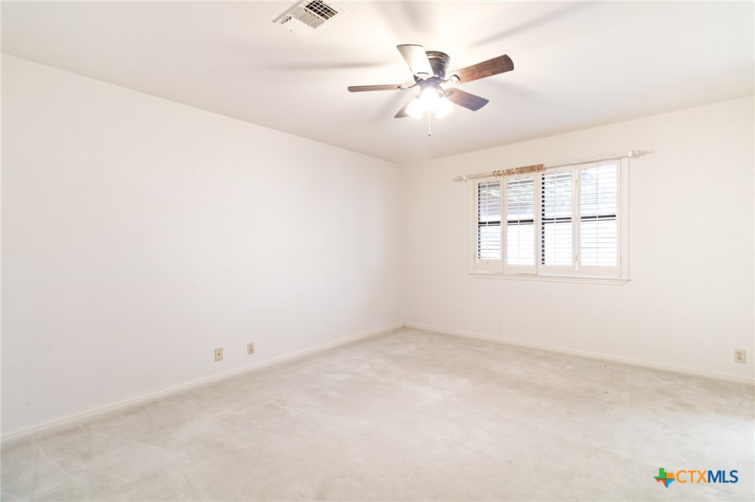 603 Suzanne Street Edna, TX 77957 - Photo 20 of 45 an empty room with chandelier fan and windows