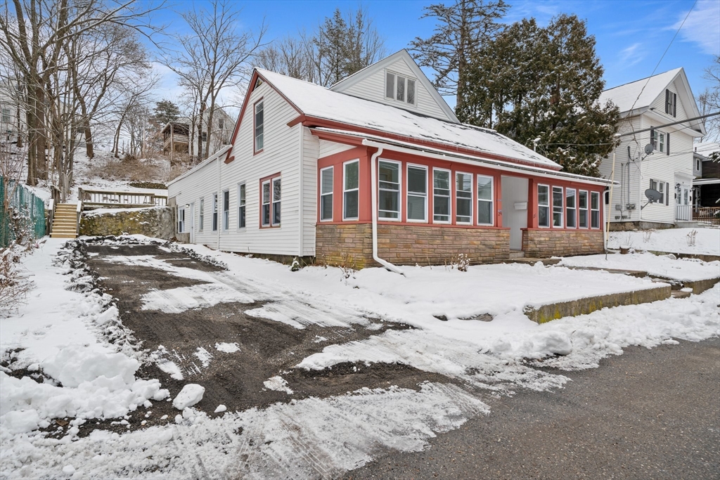 a front view of a house with a yard covered in snow