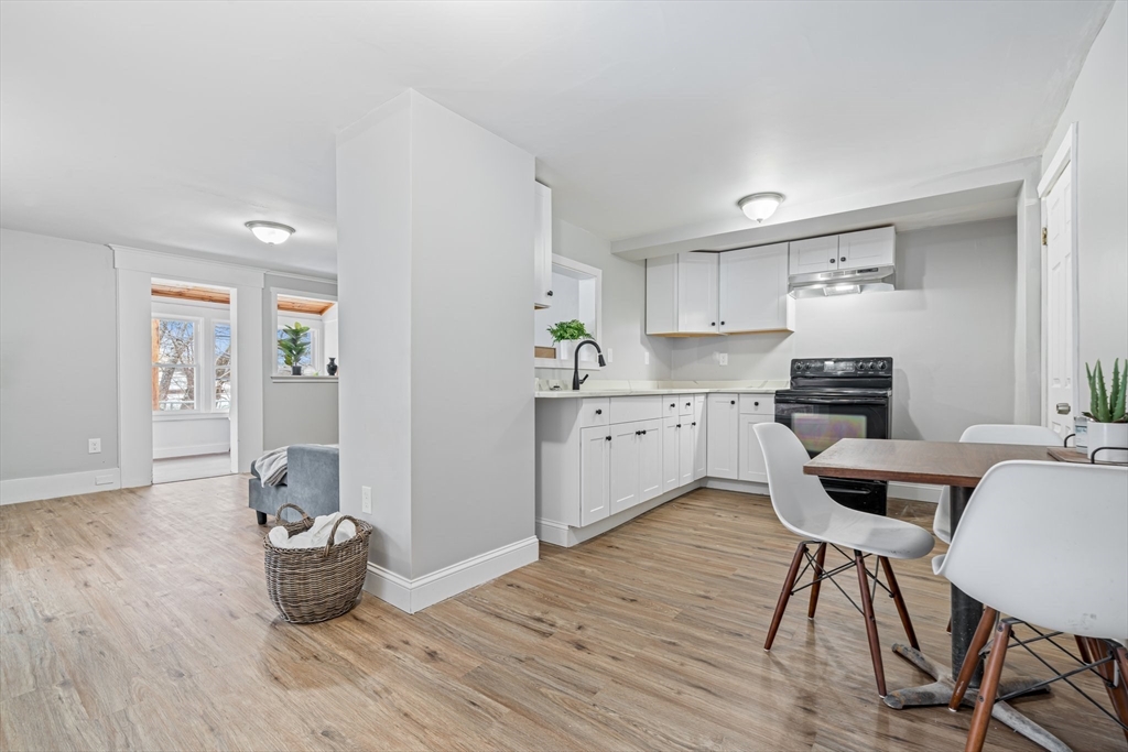 124 Cottage Street Athol, MA 01331 - Photo 16 of 38 a kitchen with stainless steel appliances kitchen island wooden floors and view living room