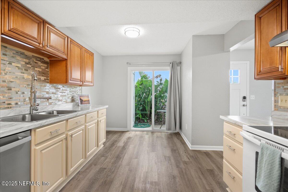 a kitchen with a sink wooden floor and a window
