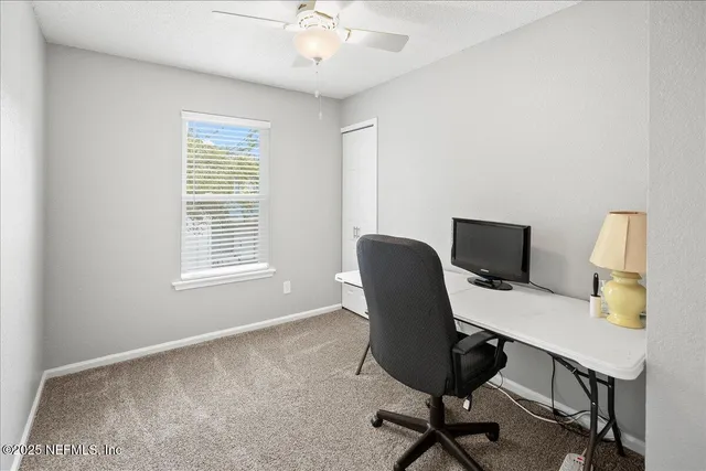 a view of a workspace with furniture and a window
