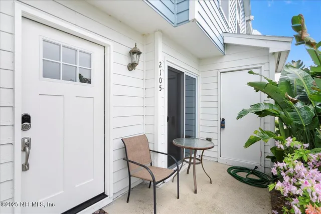 a view of patio with a table and chairs and potted plants