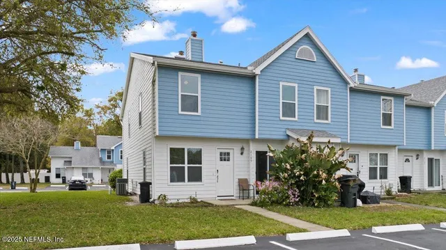 a front view of a house with a yard and trees