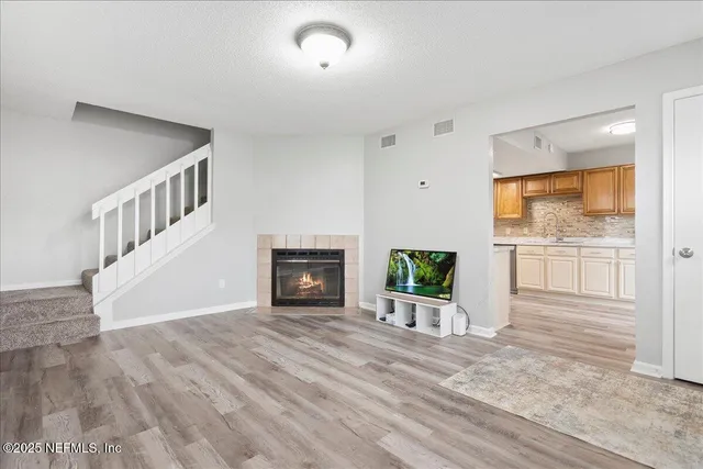 a view of an empty room with a fireplace and a window