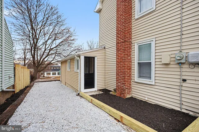 a view of a yard with a wooden fence and a large tree