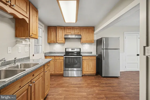 a kitchen with a refrigerator sink and cabinets