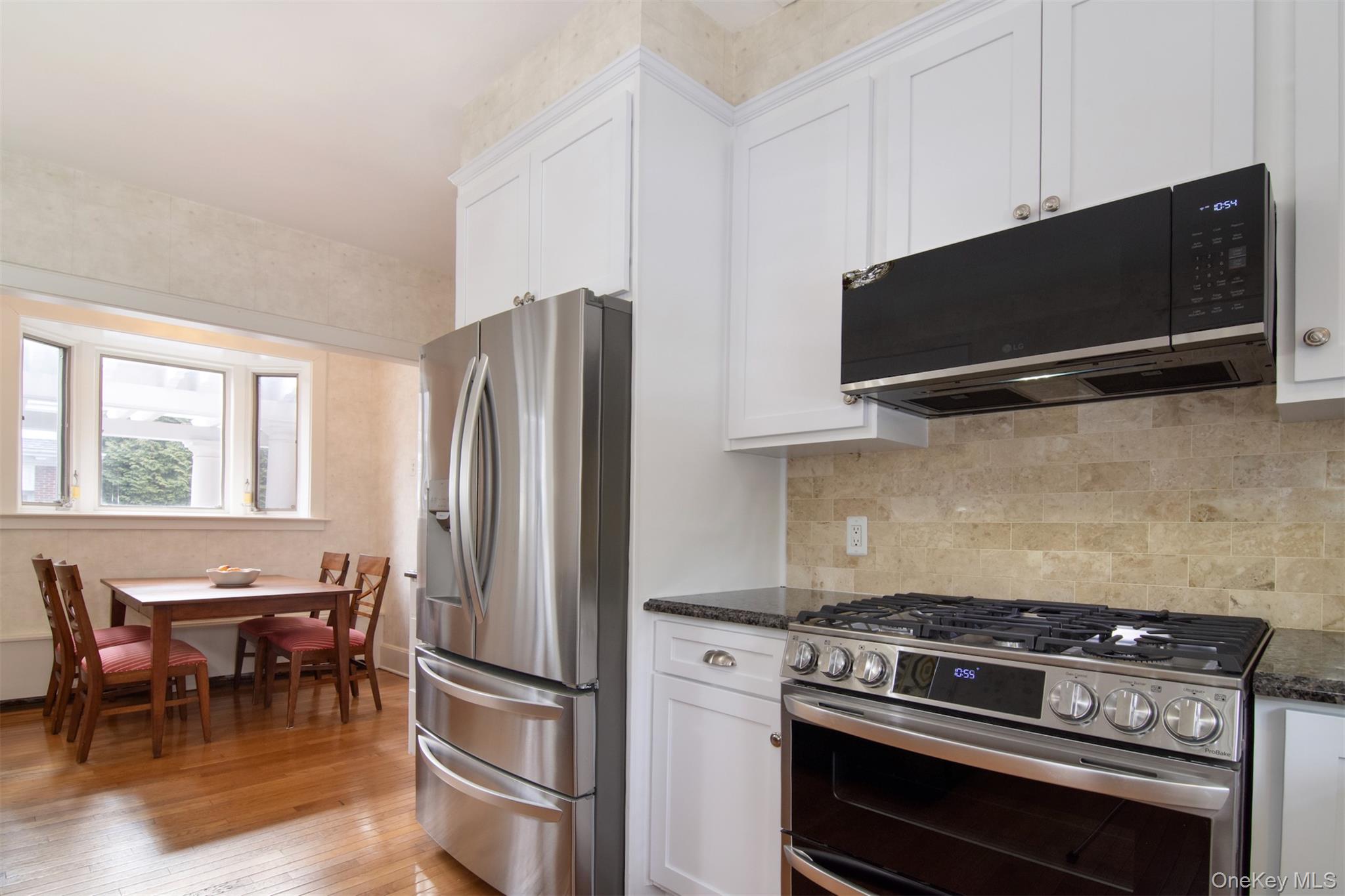 4610 Boston Post Road Pelham, NY 10803 - Photo 15 of 32 a kitchen with stainless steel appliances a stove a microwave and a refrigerator