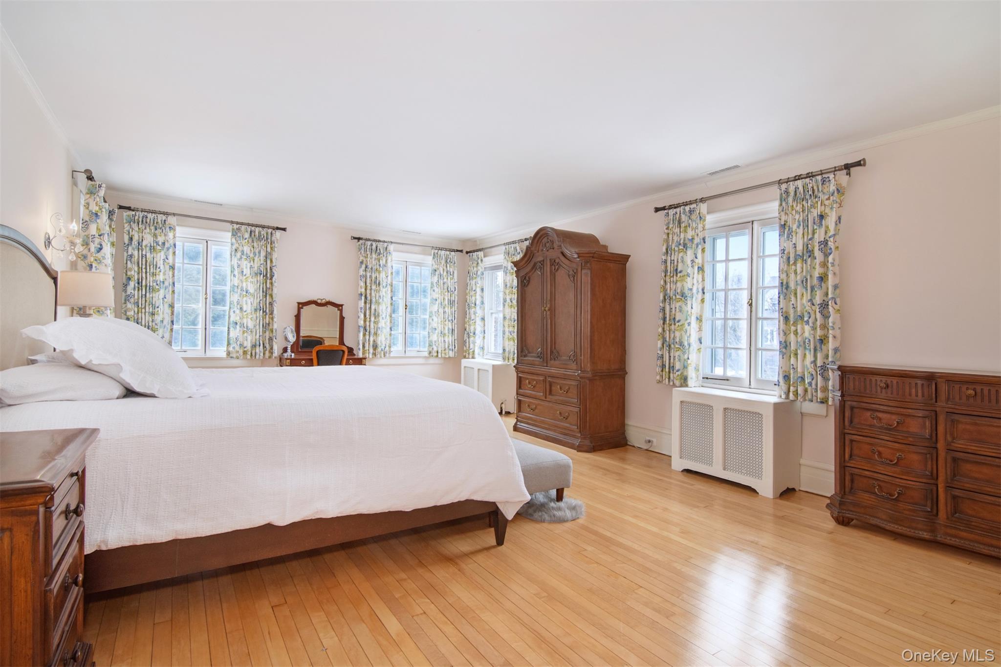 4610 Boston Post Road Pelham, NY 10803 - Photo 21 of 32 a spacious bedroom with a bed a dresser and wooden floor
