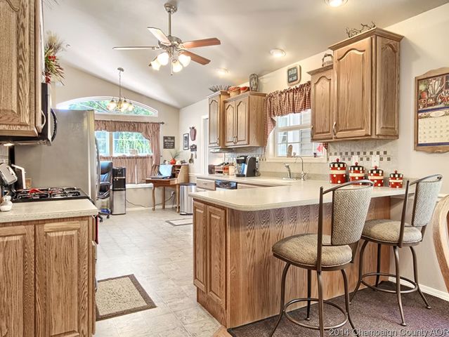 7841 Buttercup Road Weldon, IL 61882 - Photo 8 of 24 a kitchen with stainless steel appliances granite countertop a stove top oven a sink a dining table and chairs with wooden floor