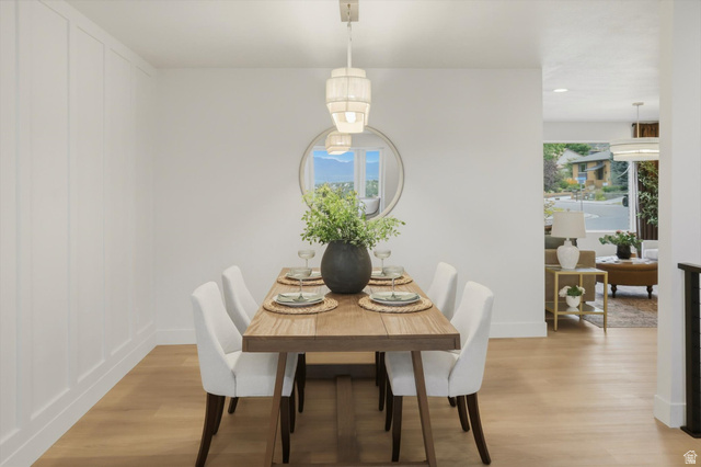 8760 Rustler Road Cottonwood Heights, UT 84093 - Photo 13 of 57 Dining area featuring a contemporary chandelier, wood-finish flooring, and wainscoting details on one wall