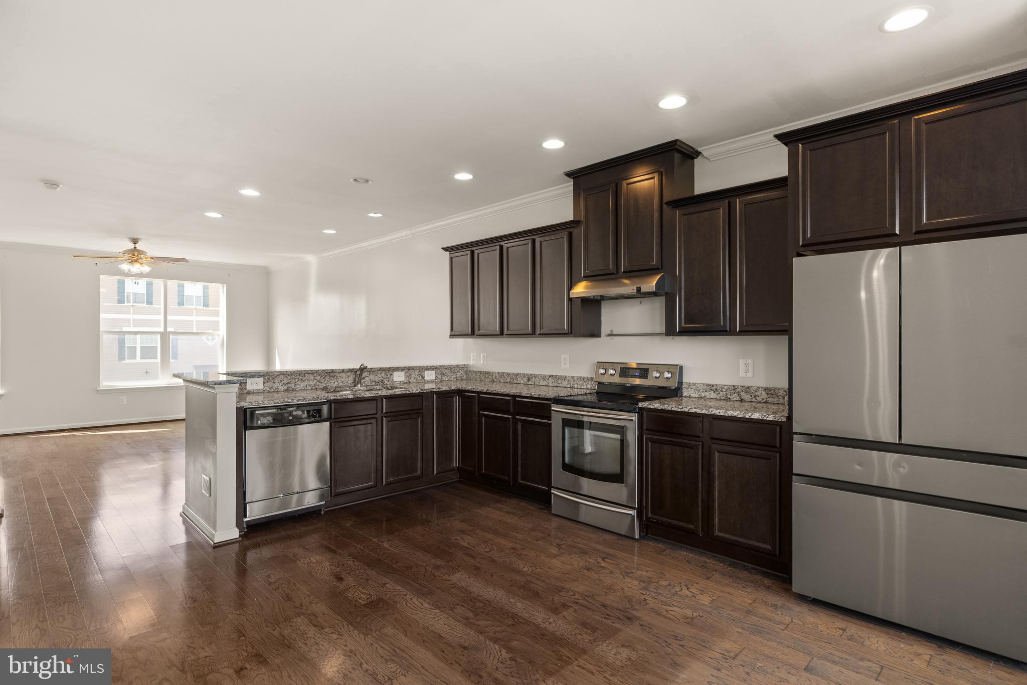 111 Rotunda Drive Stephenson, VA 22656 - Photo 6 of 33 a large kitchen with stainless steel appliances granite countertop a refrigerator stove a sink dishwasher and wooden cabinets with wooden floor