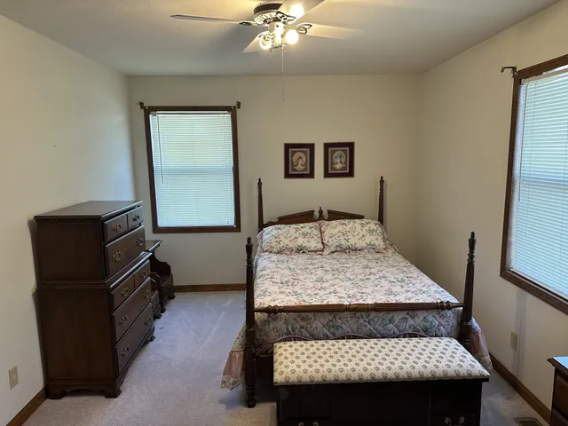 a bedroom with a bed and a flat tv screen on dresser