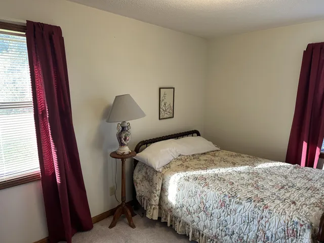 a bedroom with a bed and a large mirror on dresser