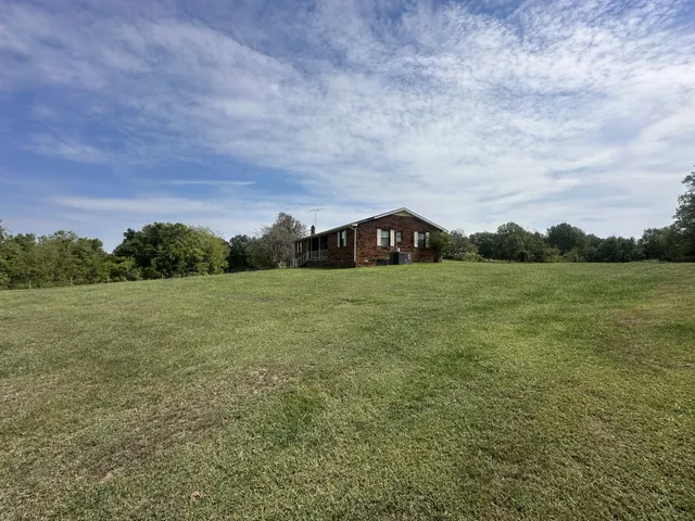 a view of a field with an trees in the background