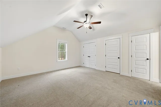 an empty room with closet and windows