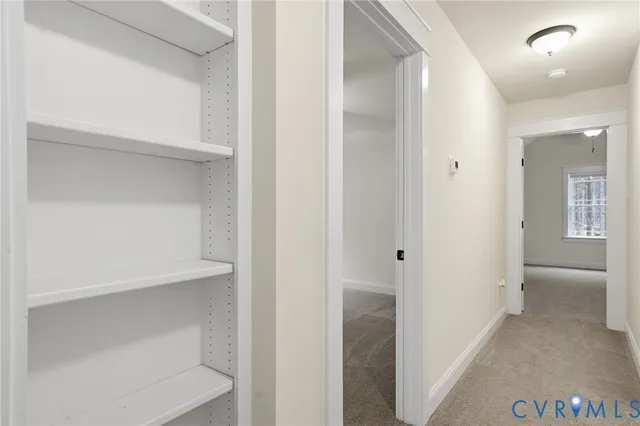 a view of a hallway with wooden shelves