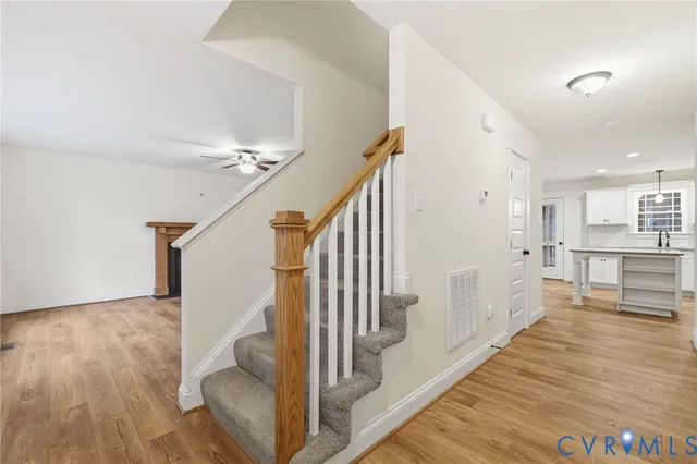 a view of a living room with wooden floor and stairs