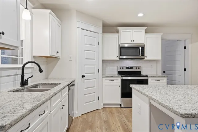 a kitchen with granite countertop a sink and stainless steel appliances