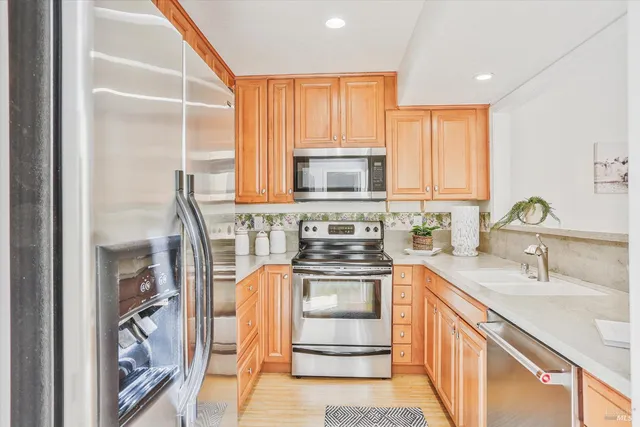 a kitchen with stainless steel appliances granite countertop a sink stove and refrigerator