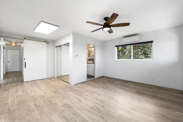 a view of empty room with wooden floor and window