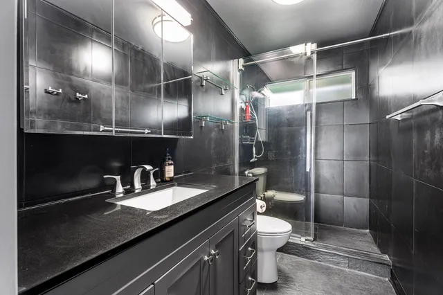 a bathroom with a double vanity sink toilet and shower