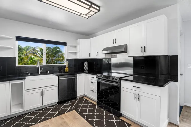 a kitchen with stainless steel appliances a stove sink microwave and cabinets