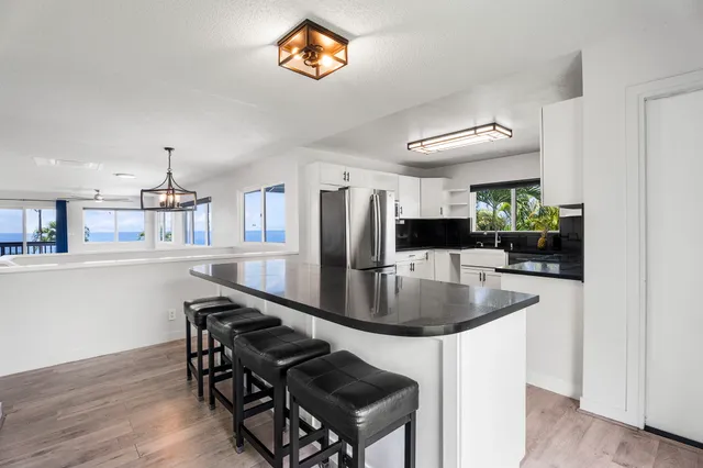 a kitchen with stainless steel appliances granite countertop a stove a kitchen island a dining table and chairs