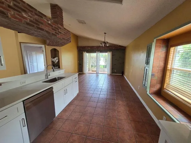 a large kitchen with a large window and stainless steel appliances