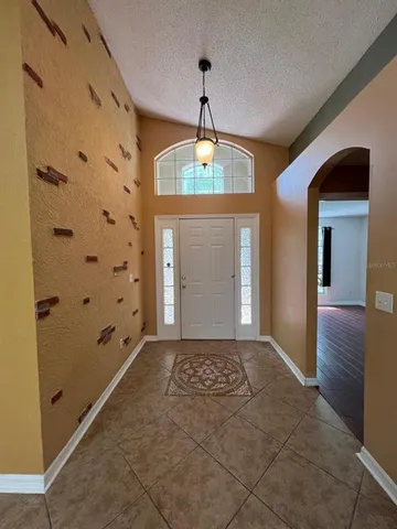 a view of a hallway with windows and chandelier