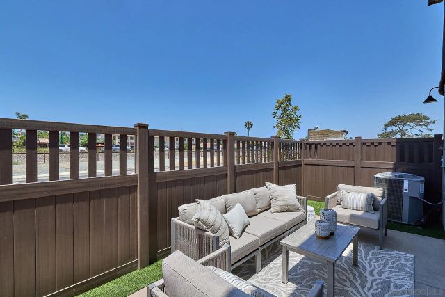 a roof deck with couches and wooden fence