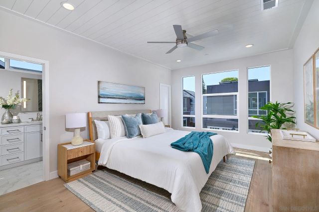 a spacious bedroom with a large bed and a potted plant