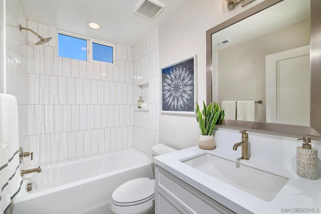 a bathroom with a sink a bathtub a mirror a vanity and a shower