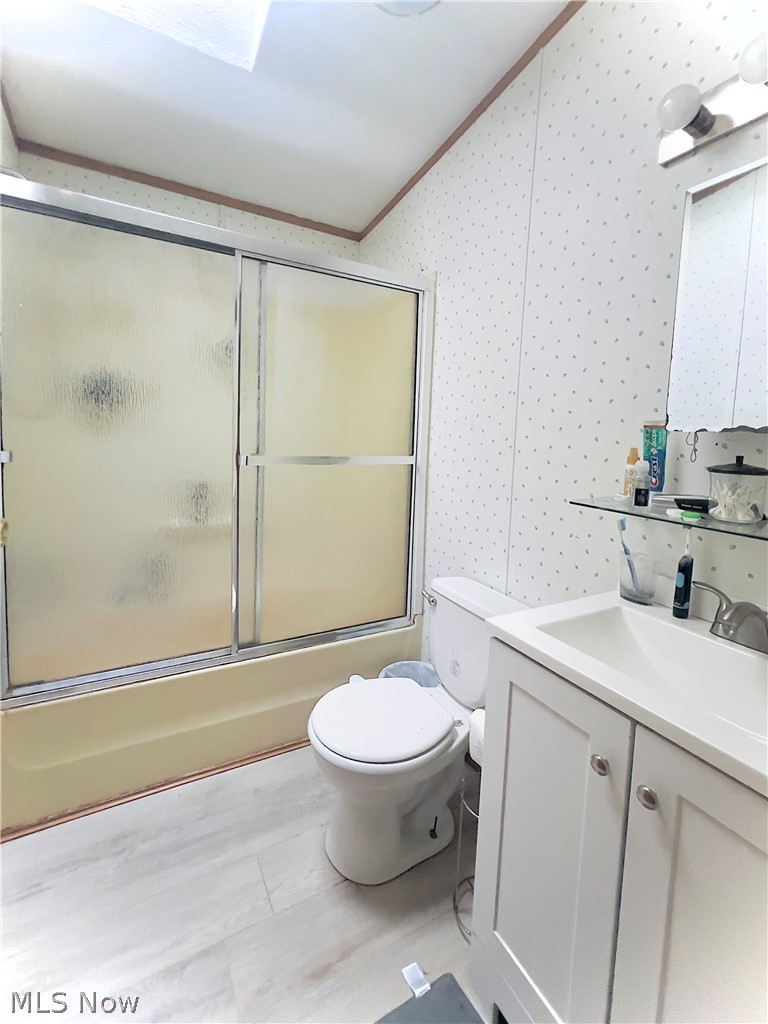 3585 Austin Road, Unit 9 Geneva, OH 44041 - Photo 14 of 18 Three-piece bathroom featuring a shower with sliding doors, a white toilet, and a vanity with a white sink