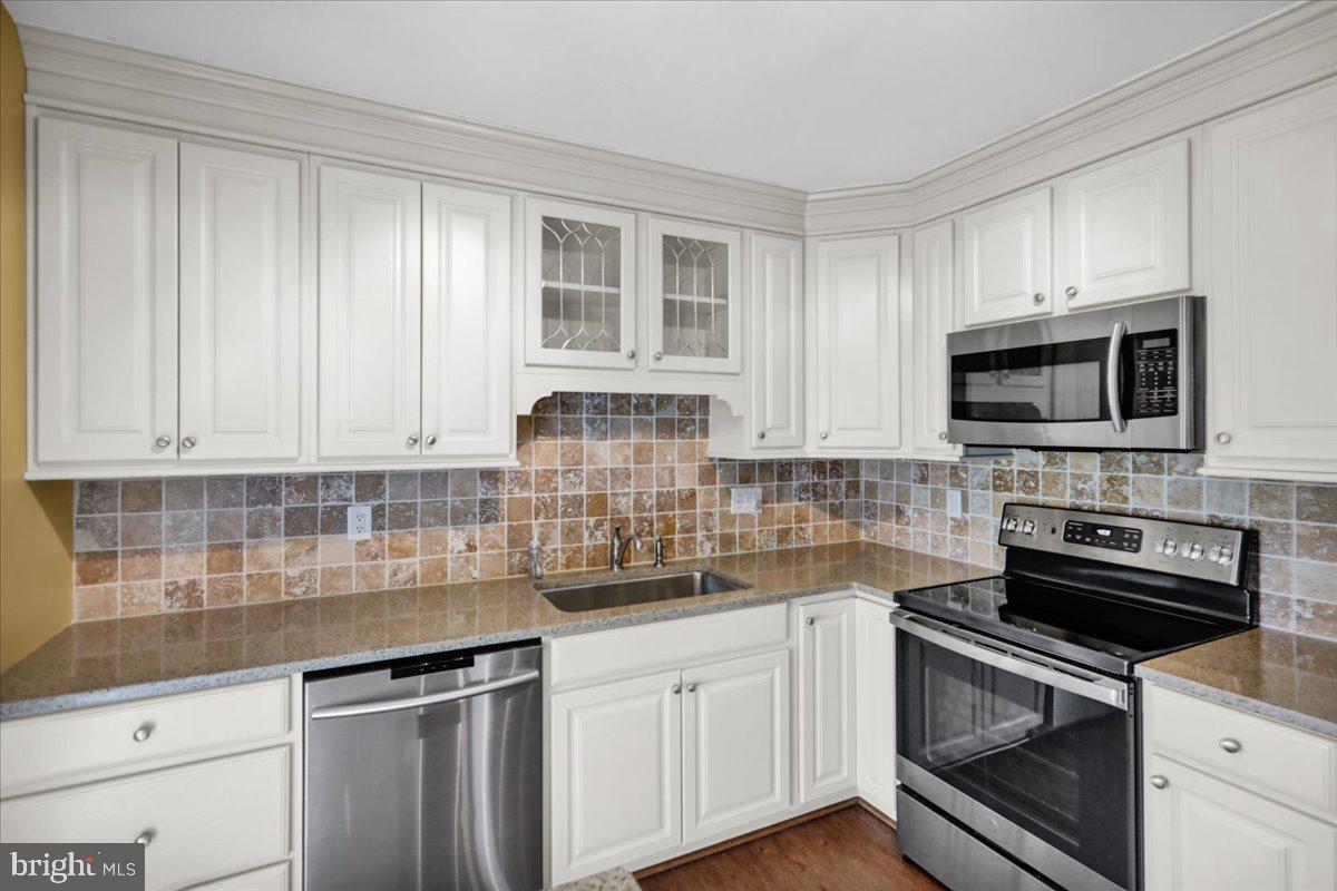 112 Brown Street Reading, PA 19606 - Photo 11 of 32 a kitchen with stainless steel appliances white cabinets and a stove top oven