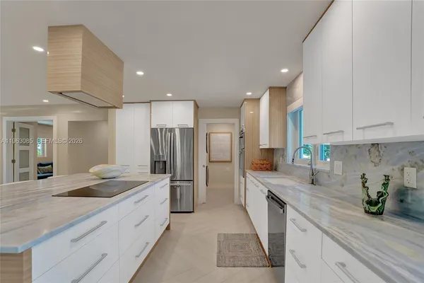 a large kitchen with a large counter top stainless steel appliances and cabinets