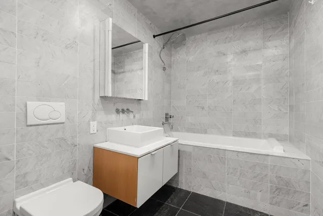 an empty room with wooden floor chandelier and windows