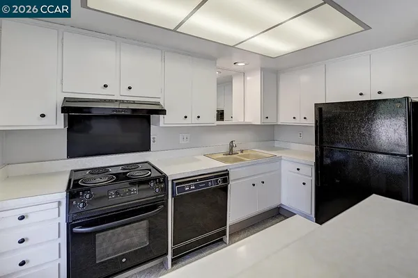 a view of kitchen with stainless steel appliances granite countertop a refrigerator and a stove top oven