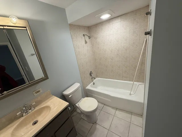 a bathroom with a sink a toilet a mirror and shower