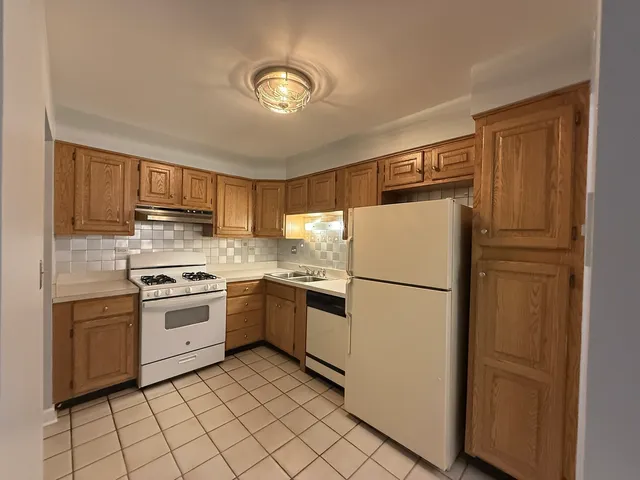 a white refrigerator freezer and a stove in a kitchen